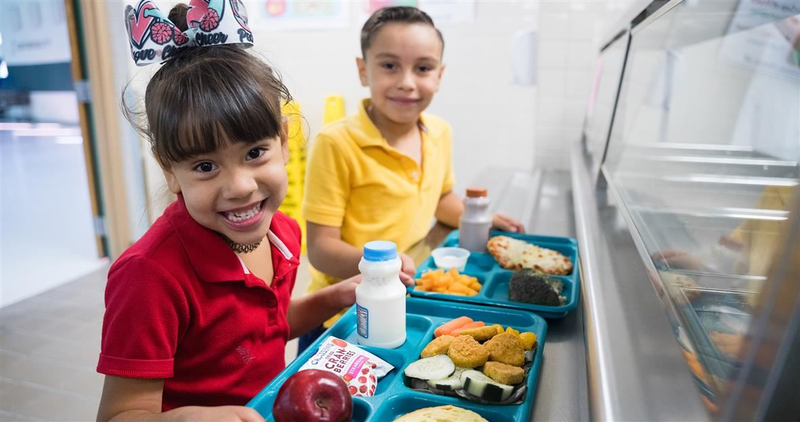 SISD students holding food trays